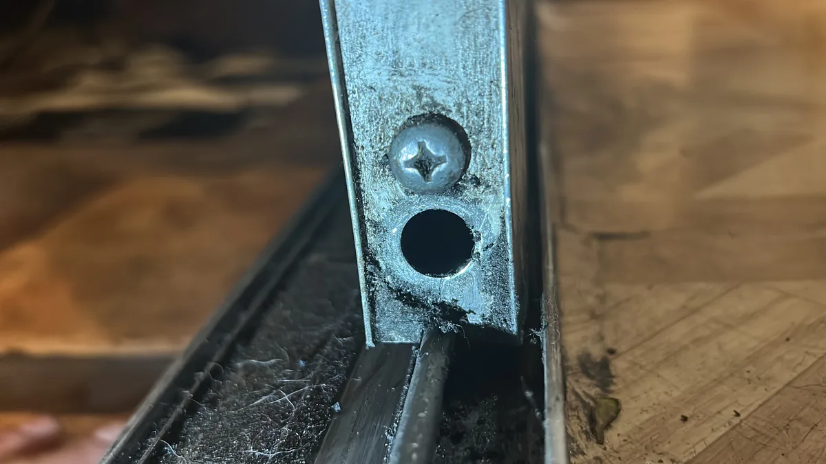 Worn sliding door roller assemblies removed from a patio door